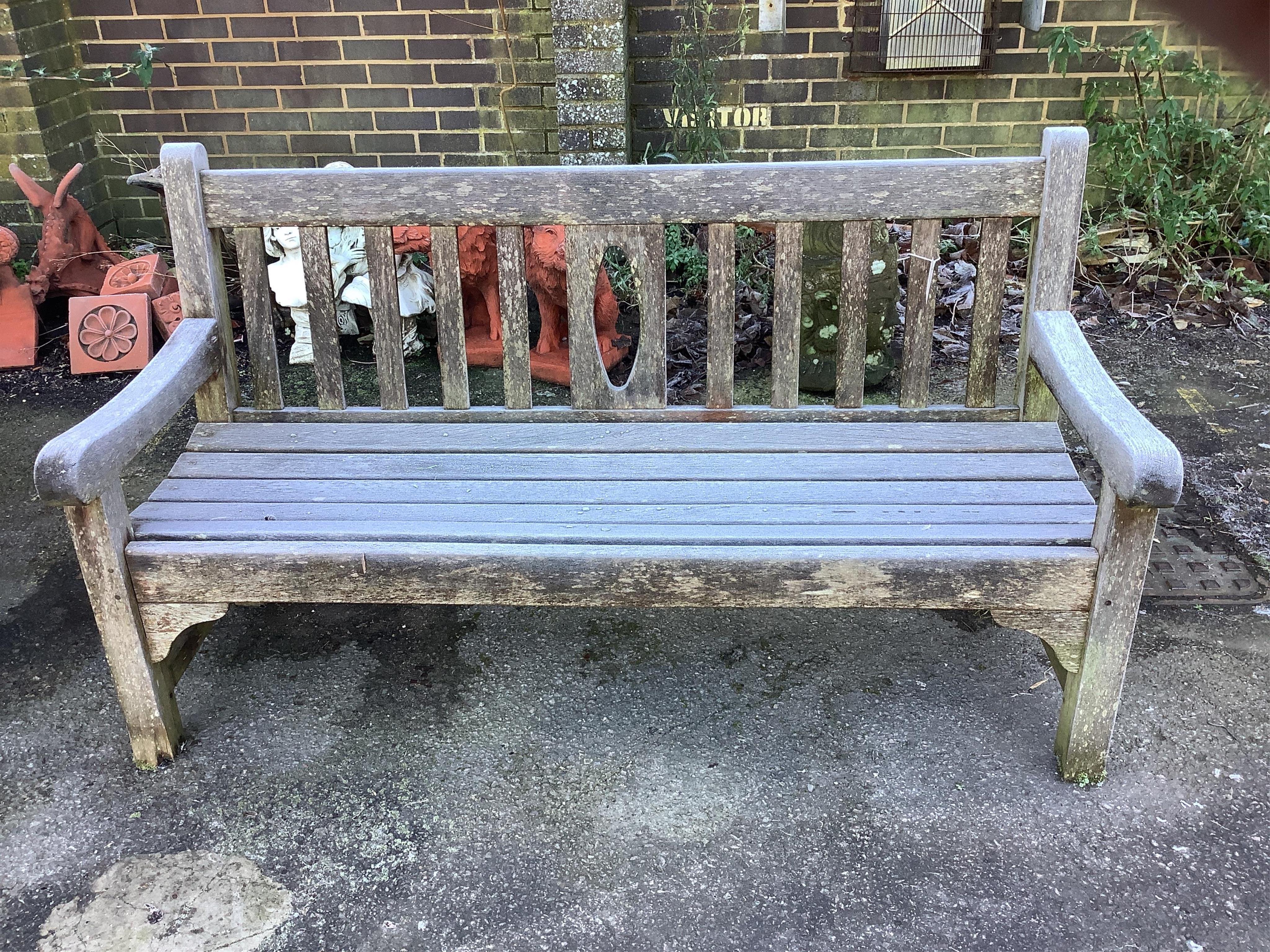 A teak garden bench and a teak circular table, table diameter 148cm, height 70cm. Condition - fair